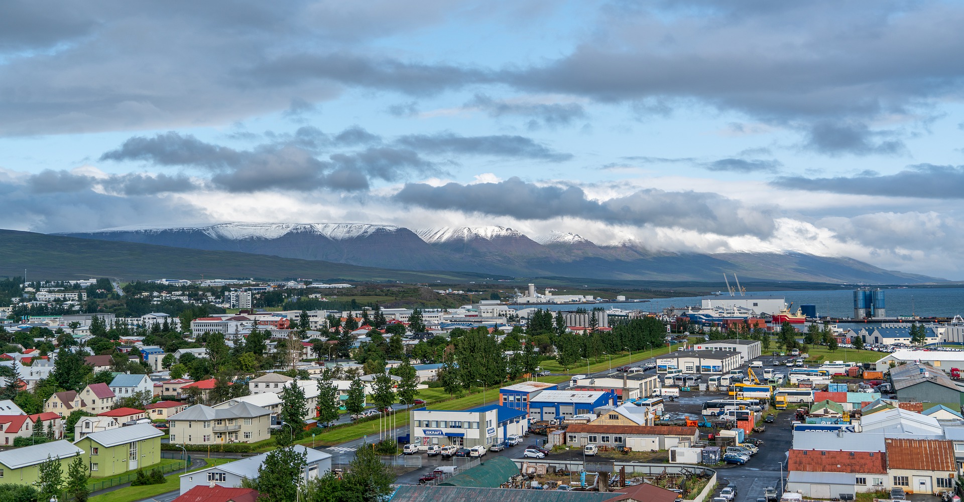 the city of akureyri with colorful houses and mountains on the background