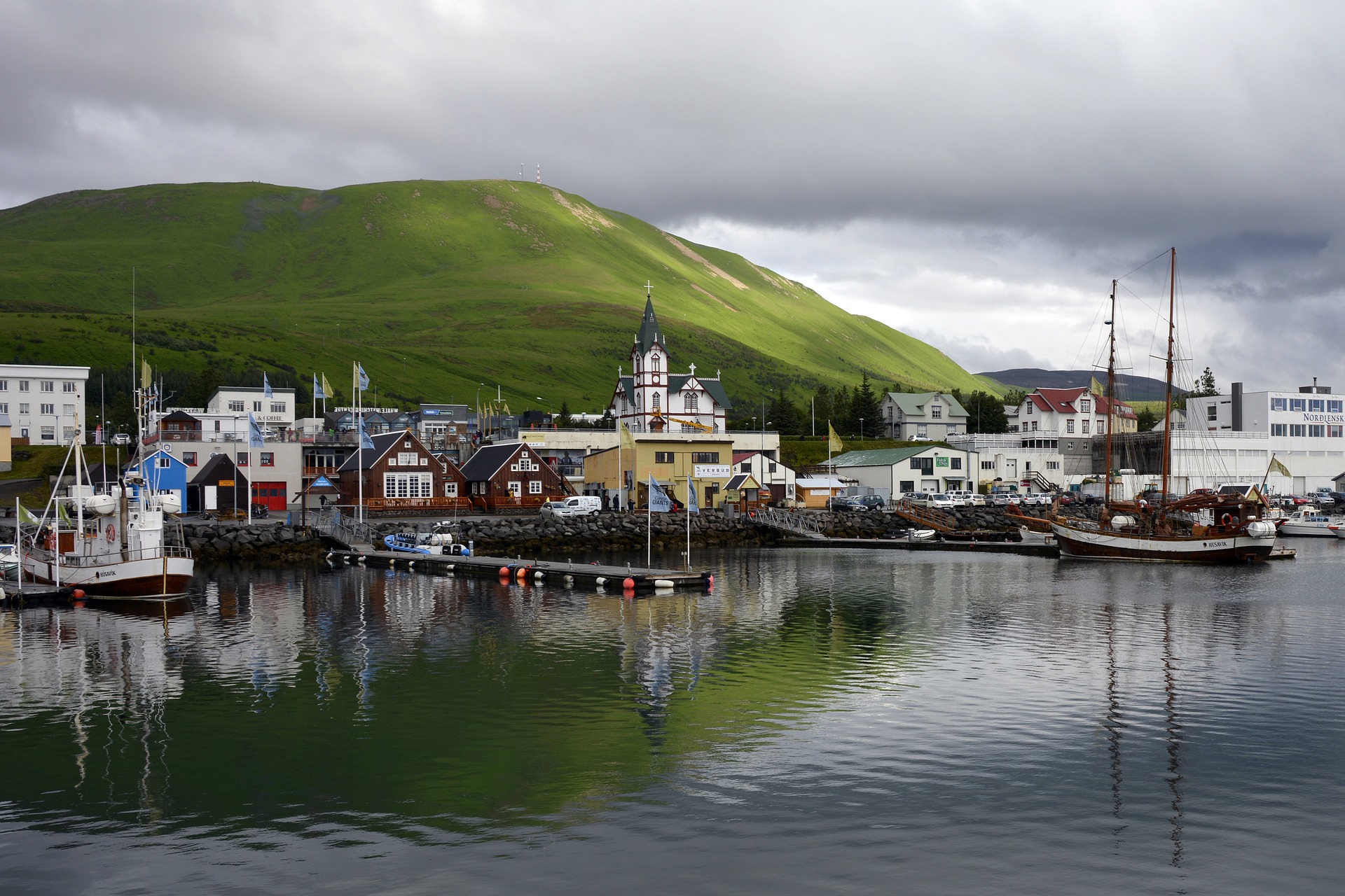 Husavik in Iceland harbor with boats and blue sky