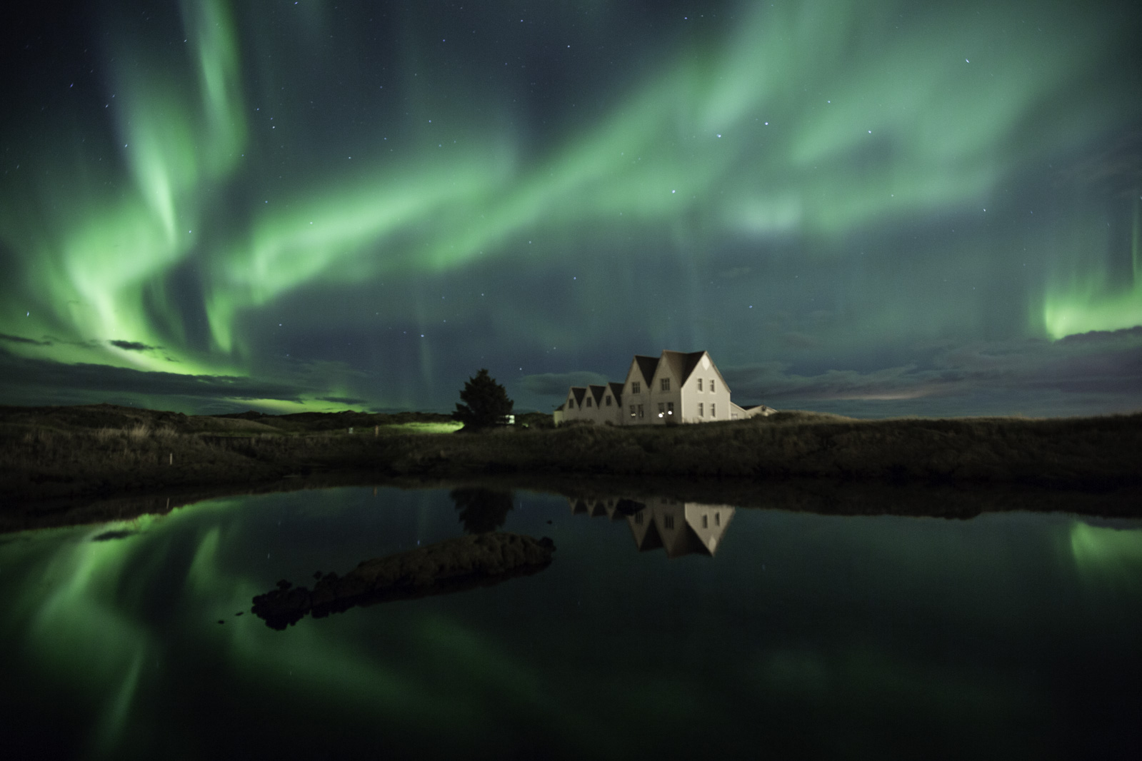 green northern lights with houses